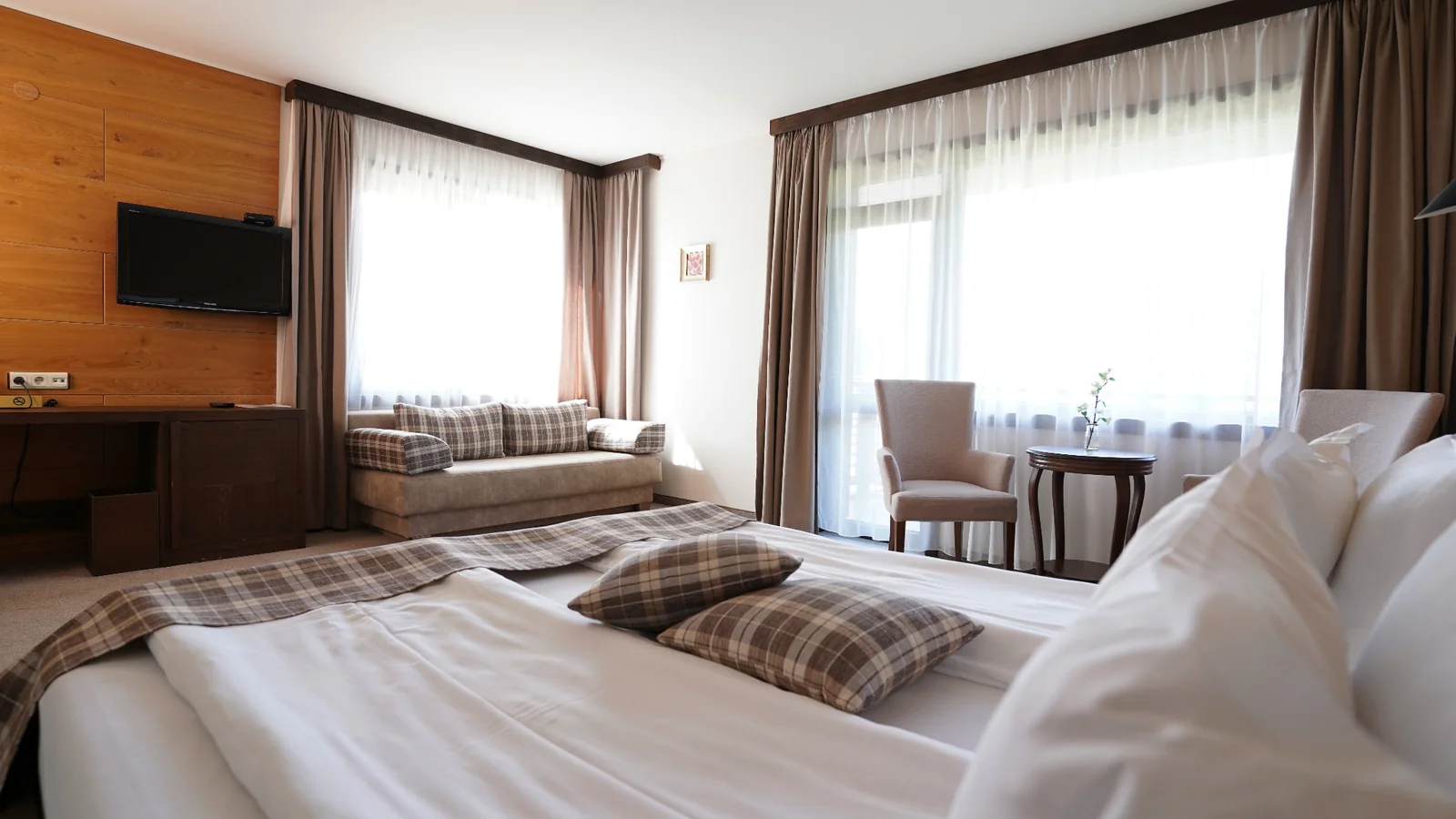 Bright hotel room with a double bed and seating area