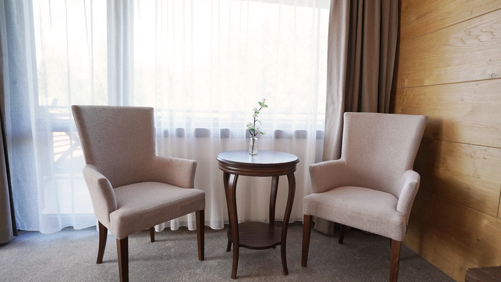 Armchairs and a table beside the window